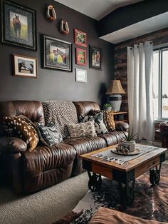 a living room with brown leather couches and pictures on the wall above it's coffee table