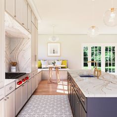 a large kitchen with white cabinets and marble counter tops