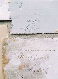 the wedding stationery is laid out on top of each other