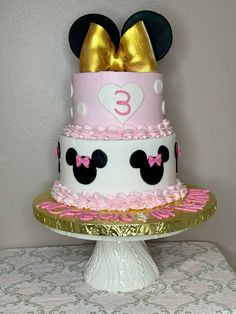 a three tiered cake decorated with minnie mouse ears