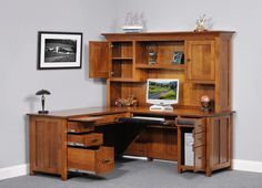 a wooden desk with drawers and a computer monitor