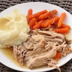 a white plate topped with meat, mashed potatoes and carrots