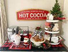 a christmas display with hot cocoa, cookies and other holiday treats on a black counter