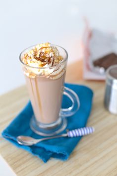 there is a drink with whipped cream in it on the table next to other items