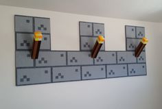 the wall is made out of legos and has three pieces of paper on it