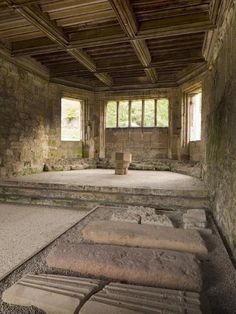 an empty room with stone steps and windows