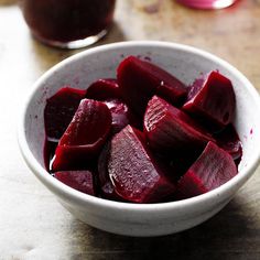 a white bowl filled with beets on top of a table