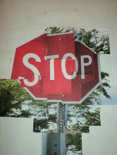 a red stop sign sitting on top of a metal pole with trees in the background