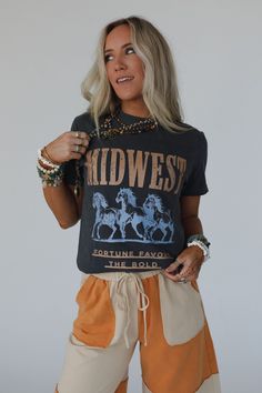 No boho closet is complete without the perfect graphic tee, and the Midwest Fortune Graphic Tee is it! So cool, you won’t want to miss out! Comfortable, mineral-washed, Cotton tee shirt fabric Relaxed and slouchy silhouette for ultimate comfort Classic crew neckline with dropped shoulders and loose short sleeves So cool Western Inspired Running Wild Horses with "MIDWEST - Fortune Favors the Bold" print Pair with: Eye Of The Sun Padded Bralette, The Signature Flare and Shoreline Platform Sandals. Festival Acid Wash Soft-washed T-shirt, Festival Washed Graphic T-shirt, Festival Washed Graphic Tee T-shirt, Festival Graphic Tee T-shirt Washed, Acid Wash Graphic Tee For Festival, Festival Graphic Tee With Washed Detail, Festival Acid Wash Graphic Tee Tops, Festival Acid Wash Graphic Tee, Casual Acid Wash T-shirt For Festivals