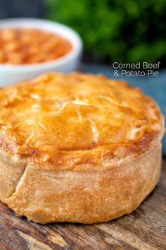 a baked pot pie sitting on top of a wooden cutting board