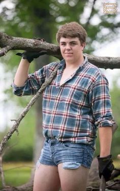 a young man standing next to a tree branch