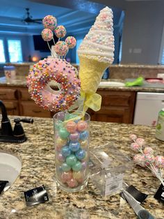 an ice cream cone with sprinkles and candies in it on a counter