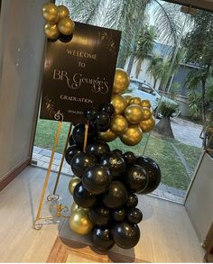 a welcome sign and balloons in front of a window at a graduation party or celebration