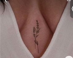 a woman's chest with a small flower tattoo on the left side of her stomach