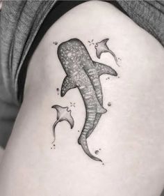 a woman's thigh with a shark and dolphins tattoo on the side of her leg