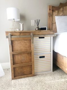 a bed room with a neatly made bed and a wooden cabinet next to the bed