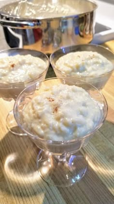 three glasses filled with oatmeal sitting on top of a wooden table