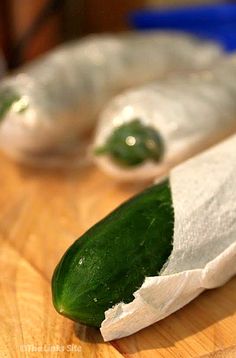 two cucumbers sitting on top of a wooden cutting board