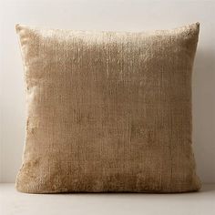 a beige pillow sitting on top of a white table