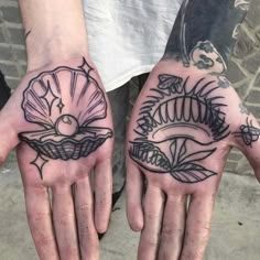 two hands that have tattoos on them, one with an eye and the other with a shell