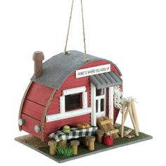 a red and white birdhouse with a sign that says home is where you are