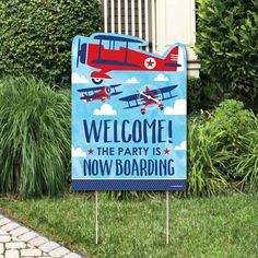 a welcome to devon's airplane party sign in front of some bushes and shrubs