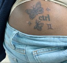 the back of a woman's stomach with butterfly tattoos on her left shoulder and name written in cursive writing