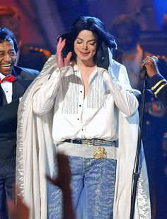 a woman in white shirt and blue jeans on stage