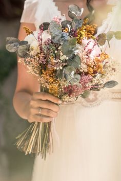 a woman holding a bouquet of flowers in her hands