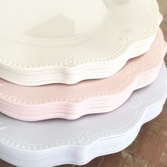 three white and pink plates stacked on top of each other