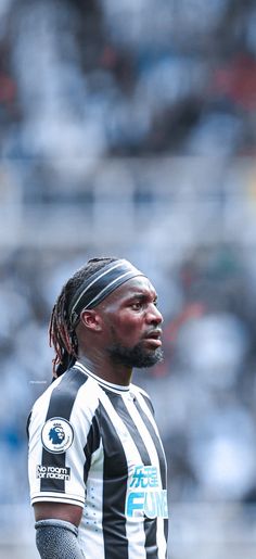 a man with dreadlocks standing in front of a crowd