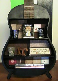 a guitar shaped book shelf with books on it