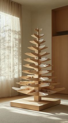 a wooden christmas tree sitting in front of a window