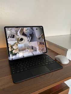 an open laptop computer sitting on top of a wooden desk next to a mouse and keyboard