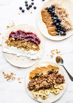 three breakfast burritos with fruit, yogurt and granola on them