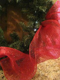 a close up of a christmas tree with red ribbon on it's headband