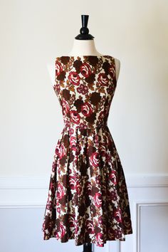 Gorgeous 1960's dress by Jonathon Logan. Cream cotton with beautiful rose print in rich browns and deep reddish pink. The front features a high, squared neckline. The back is so lovely with a deep V that ties, and adorable black buttons that lead all the way down to the hem. The waist is nipped and the skirt is full. SUCH a charming frock! This dress is in wonderful condition with just a faint spot near the waistline. Freshly dry cleaned and ready to wear! Label- Jonathon Logan Bust 32" Waist 25 1960’s Dresses, Vintage Fashion 1960s, Boucle Coat, Fashion 1960s, 1960's Dress, Vintage Glam, 1960s Fashion, Beautiful Rose, Rose Print