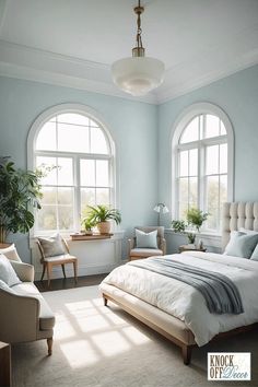 a bed room with a neatly made bed next to two large windows and a potted plant