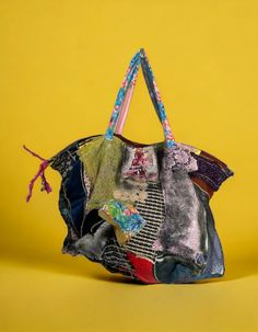 a handbag made out of old clothes on a yellow background