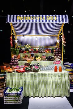 a food stand with lots of fresh fruits and vegetables on it's display table