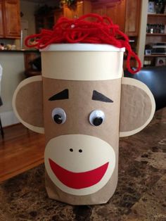 a paper cup with a monkey face on it's side and eyes drawn onto the top