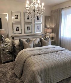 a bedroom with a bed, chandelier and pictures on the wall above it