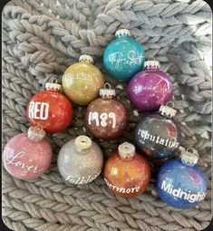 a basket filled with lots of different colored christmas ornament ornaments on top of a blanket