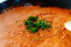 a pan filled with soup and garnished with parsley