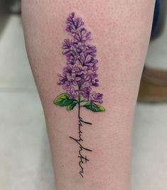 a woman's leg with a purple flower tattoo on her left calf and the word faith written in cursive writing