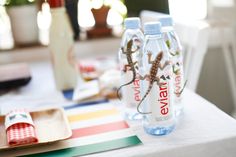 two water bottles sitting on top of a table next to plates and utensils