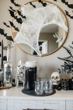 halloween decorations on a mantle with a mirror and black candlesticks in the background