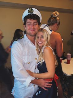 a young man and woman dressed in sailor attire posing for a photo at an event