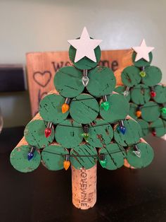 a small christmas tree made out of wine corks with white stars on the top