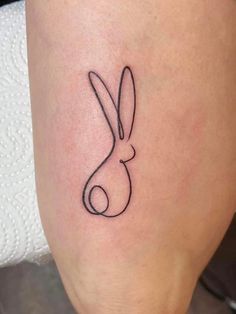 the outline of a rabbit tattoo on the leg is shown in black and grey ink